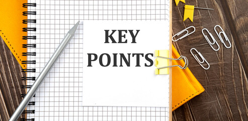 KEY POINTS, text on a sticker on notebook, wooden background