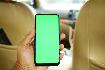  hand holding smart phone with empty screen in a car 