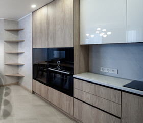 Modern interior of spacious light wooden kitchen in apartment.