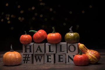 Various toy pumpkins for Halloween against on wooden cubes