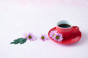 Obraz na płótnie Canvas ピンクの小菊と赤いカップのコーヒー（ピンクの背景）