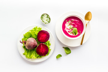 Cream soup made of red beet with raw beet roots