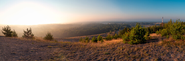panorma from the mining heap overlooking vast forests and mines among trees. Morning mists and autumn sun