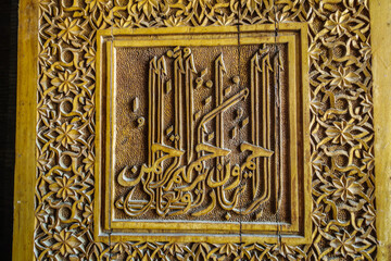 Details of woodcarving with Eastern ornaments. Entrance door to mausoleum of Qutham ibn Abbas. Historical complex Shah-i Zinda, Samarkand, Uzbekistan
