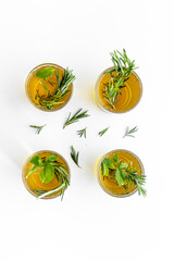 A lot of glasses of lemonade with cold tea and rosemary