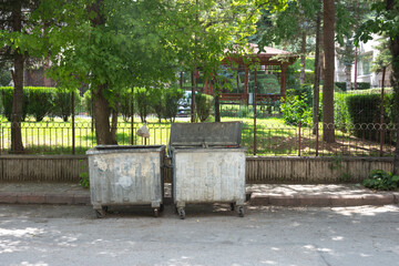 Garbage containers under trees on a roadside in Istanbul. Space for copy