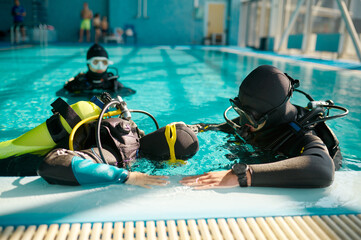 Instructor and divers in aqualungs, diving school