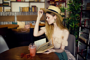 pretty woman with a book in the hands of a cafe communication