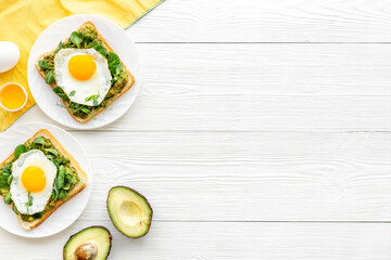 Fototapeta na wymiar Toasts with eggs and avocado cream and spinach. Top view