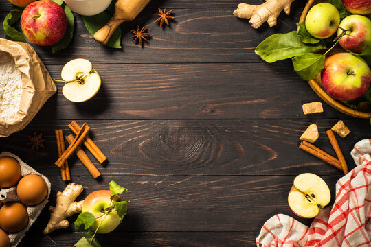 Autumn baking background. Ingredients for cooking apple pie at dark wooden table. Top view image with copy space.