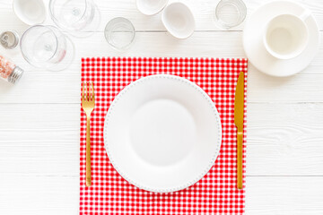 Fototapeta na wymiar Dinner plate setting with cutlery and napkin. Top view