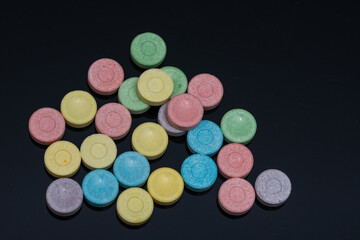 a bunch of 6 colored pills on black