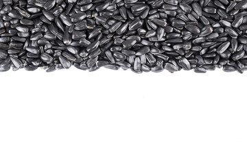 Heap of black sunflower seeds close-up on a white background with copy space