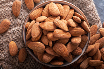 Roasted almonds on stone table and in clay bowl