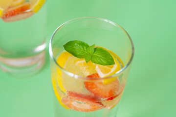 Refreshing strawberry lemonade in glasses. Green background
