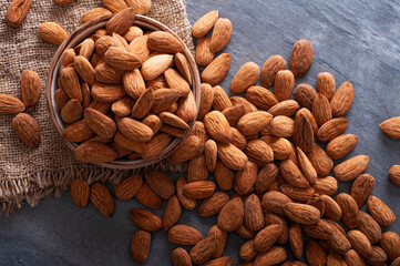 Roasted almonds on stone table and in clay bowl