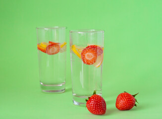 Refreshing strawberry lemonade in glasses. Green background