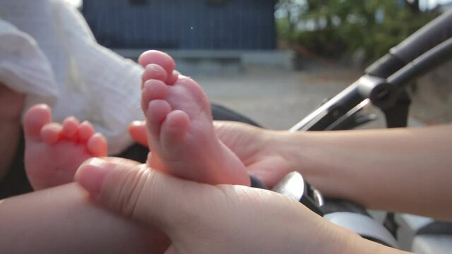Mom touches her baby on stroller