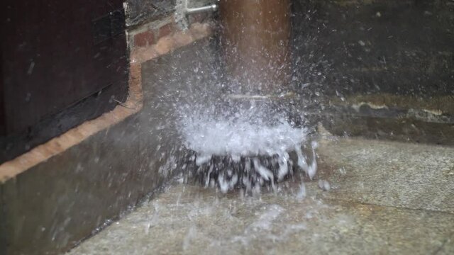 Water Splashing Out of Gutter Downspout During Heavy Rainfall