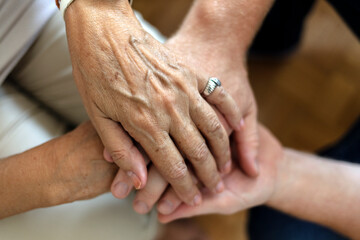 A cropped shot of a man holding a loved one's hand in support. Grandson gives grandmother his...