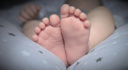 Newborn baby feet on a bed