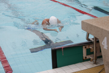 A swimmer competing in a breaststroke is approaching the finish line.