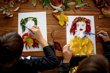 Child, creating woman portrait of leaves in living room, applying leaves using glue