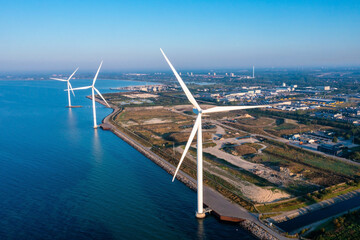 Aerial view of the wind turbines. Green ecological power energy generation. Wind farm eco field. Offshore and onshore windmill farm green energy at sea. - obrazy, fototapety, plakaty