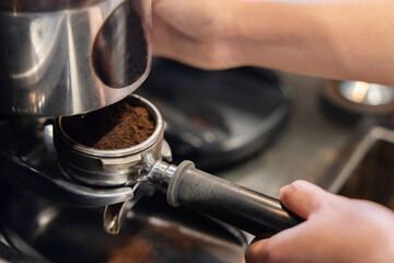 Fototapeta na wymiar Barista Using Coffee Grinder to Make Fresh Roasted Coffee Powder