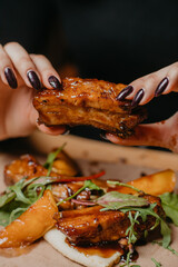 delicious ribs in the hands of a girl
