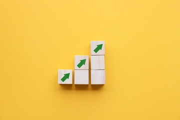 Wooden blocks lined up with up arrow icon The process of creating a successful business concept