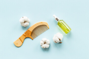 Fototapeta na wymiar Hair treatment by cotton oil with hair comb. Top view