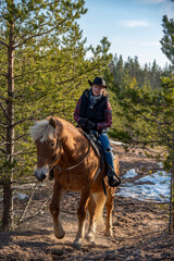 Woman horseback riding in forest