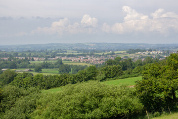 typical Devon rolling countryside with fields, hedges and cloudy pale blue sky