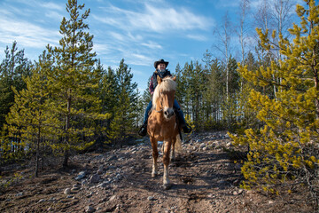 Woman horseback riding in forest
