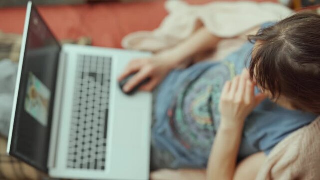 top view woman with laptop on sofa. female freelancer working at laptop at home.