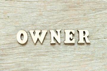 Alphabet letter in word owner on wood background