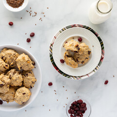 Top down view of homemade cranberry flax breakfast cookies with a bottle of milk, ready for eating.