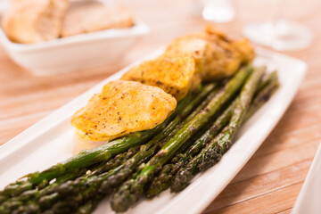 fried chicken breast pieces with asparagus on white plate