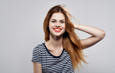 Fototapeta premium pretty woman in a striped t-shirt gesture with his hands model studio