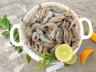 Fresh White Prawns decorated in a white bowl with herbs and fruits.Selective focus.