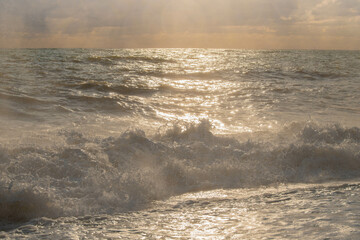 storm on the sea in the rays of sunset big waves, spray