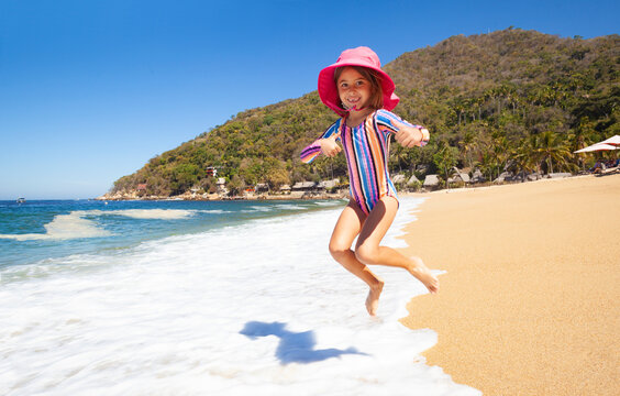 little girl jumps on the beach