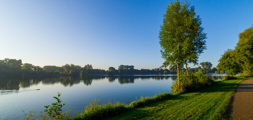 Fototapeta na wymiar Morning walk in the park, right after sunrise. View on the pond.