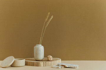 Fototapeta na wymiar Stylish minimalistic interior design with copy space, natural materials as wood and marbel, dry plants and personal accessories. Neutral and yellow colors, template.
