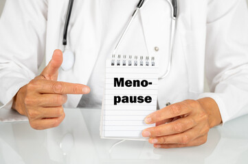 Frauenärztin mit einem Notizblock auf dem Menopause steht