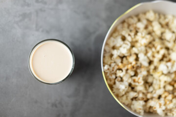 Selective focus on milk tea in glass with a big bowl popcorn