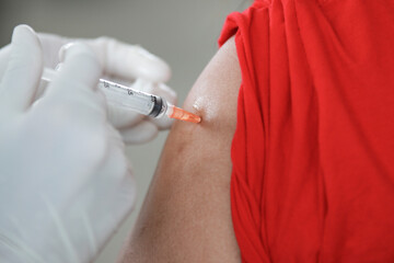 Close up Doctor injecting COVID-19 vaccine on a person's shoulder, Vaccination, immunization, disease prevention concept