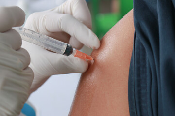 Close up Doctor injecting COVID-19 vaccine on a person's shoulder, Vaccination, immunization, disease prevention concept