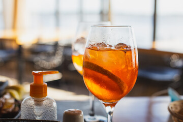 A glass of cold drink and an antibacterial agent in a city cafe